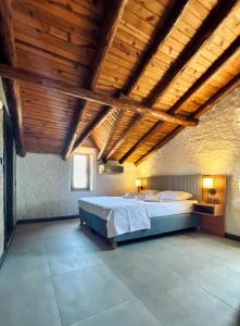 a large bedroom with a bed and wooden ceilings at Assos Ada Hotel in Ayvacık
