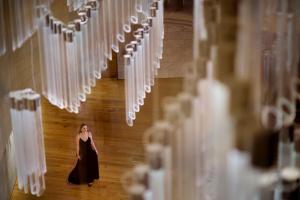 a woman in a black dress walking through a hallway with white servers at The Ritz-Carlton, Perth in Perth