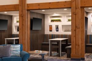a waiting room with a blue couch and tables at Courtyard Farmington in Farmington
