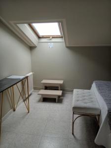 Pokój z oknem dachowym, stołem i ławką w obiekcie Hotel Migal w mieście Cue