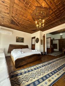 a bedroom with a large bed and a wooden ceiling at HOTEL ANSEL in Berat