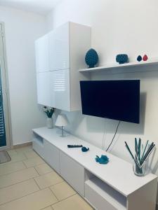 a white desk with a tv on a white wall at Casa Vacanze Matilde Marzamemi in Marzamemi