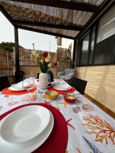 una mesa con platos y copas de vino encima en Casa Vacanze Matilde Marzamemi en Marzamemi