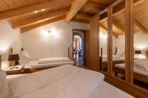 - une chambre avec 2 lits et un miroir dans l'établissement Ferienwohnung am Zehenthof, à San Giovanni