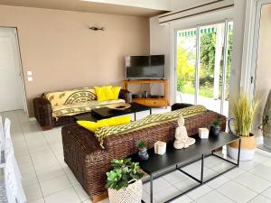 een woonkamer met een bank en een tafel bij Villa JADE, VUE MER, PISCINE PRIVEE, PLAGE A PIEDS in Le Gosier