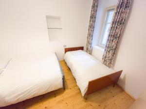 2 camas en una habitación con ventana en Apartma Florent, en Bovec