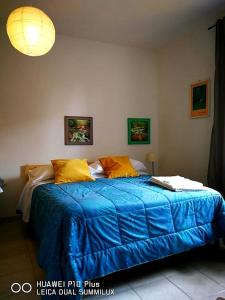 1 dormitorio con 1 cama con edredón azul en La Villetta Aeroporto Galilei, en Pisa