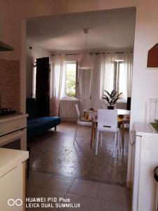 cocina y sala de estar con mesa y sofá en La Villetta Aeroporto Galilei, en Pisa
