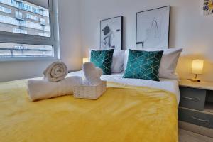 a bedroom with a large bed with towels on it at The Old Kent Hideaway by TTLG Stays in London