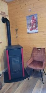 a living room with a stove and a chair at appartement Gérardmer proche lac et centre ville in Gérardmer