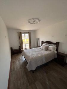 - une chambre avec un grand lit et une fenêtre dans l'établissement Refugio colonial y acogedor., à San Miguel Morazán