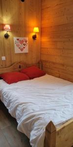 a large bed in a room with wooden walls at appartement Gérardmer proche lac et centre ville in Gérardmer