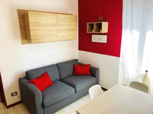 Cusano MilaninoにあるAppartamento Città Giardinoのリビングルーム(グレーのソファ、赤い枕付)