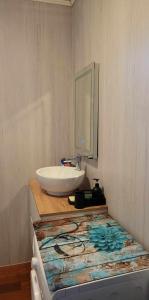 a bathroom with a white sink and a mirror at appartement Gérardmer proche lac , borne vidéo, espace exterieur in Gérardmer