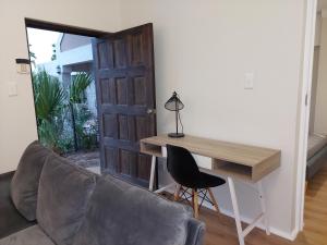 a room with a couch and a desk and a door at Pentz View in Cape Town