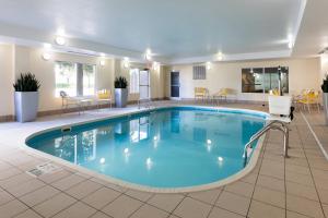 einen Pool in einer Hotellobby mit Stühlen und Tischen in der Unterkunft Fairfield Inn and Suites Austin South in Austin