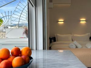 eine Schüssel Orangen auf einem Tisch in einem Zimmer in der Unterkunft Cloud 9 - Smart apartment jacuzzi in Athen