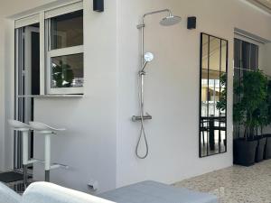 prysznic w rogu białej ściany z lustrem w obiekcie Cloud 9 - Smart apartment jacuzzi w Atenach
