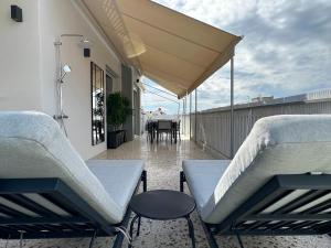 patio z krzesłami i stołem na balkonie w obiekcie Cloud 9 - Smart apartment jacuzzi w Atenach
