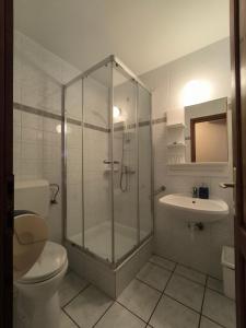a bathroom with a shower and a toilet and a sink at Korona Panzió in Balatonberény