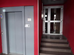 two doors and stairs in a building with a red wall at Appartement Lyon 7 Gerland in Lyon