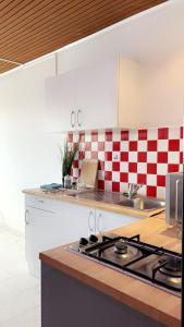 uma cozinha com azulejos xadrez vermelhos e brancos na parede em 213 Paradise Island Vue port em Cap d'Agde