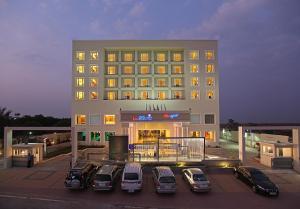 a large building with cars parked in front of it at La Classic- Attibele, Hosur in Attibele