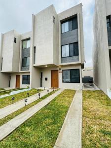 duży biały budynek z trawnikiem w obiekcie Casa Costa Azul w mieście Las Dos Palmas