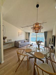 een woonkamer met een tafel en stoelen en een bank bij Point of View in Kotor