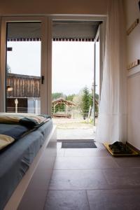 Schlafzimmer mit einem Bett und einer großen Glasschiebetür in der Unterkunft Kroneggerhof in Altmelon