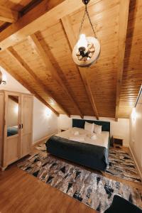 um quarto com uma cama e um tecto de madeira em Royal Alpin Crown em Cavnic