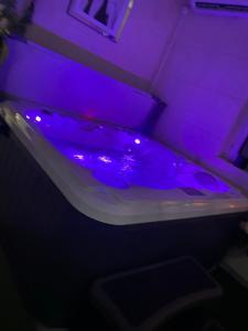 a tub with purple lights in a room at BM apartament SPA in Legnica