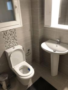 een badkamer met een toilet en een wastafel bij Sunny & Peaceful 55sq.m Flat nearby Piraeus Port in Piraeus