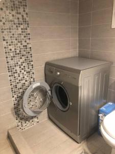 een wasmachine in een badkamer naast een toilet bij Sunny & Peaceful 55sq.m Flat nearby Piraeus Port in Piraeus