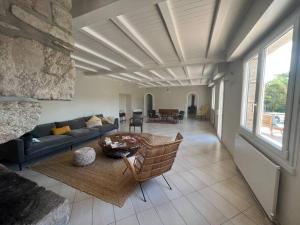 ein Wohnzimmer mit einem Sofa und einem Tisch in der Unterkunft RÉF 466 - PLOEMEUR maison avec piscine 4 chambres in Ploemeur