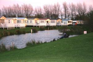 a row of houses on the side of a lake at Cleethorpes beach haven site in Cleethorpes
