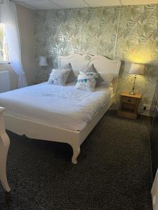 Un dormitorio con una cama blanca con almohadas. en Cleethorpes beach haven site en Cleethorpes