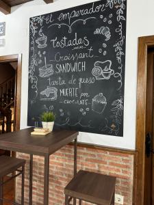 um menu de quadro negro na parede de um restaurante em Hostal El Descanso Del Emperador em Jarandilla de la Vera