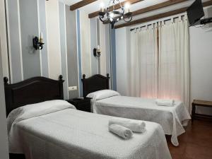 a room with two beds with towels on them at Hostal El Descanso Del Emperador in Jarandilla de la Vera +10 photos