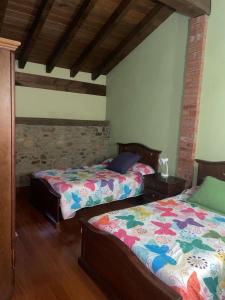 ein Schlafzimmer mit zwei Betten und einer Ziegelwand in der Unterkunft Acogedor alojamiento para familias in Abadiano Celayeta