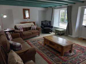 ein Wohnzimmer mit einer Couch und einem Couchtisch in der Unterkunft Secluded Cornish farmhouse in Liskeard