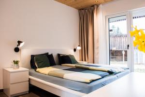Cama grande en habitación con ventana en Kroneggerhof en Altmelon