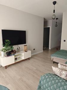 a white living room with a flat screen tv at Fuertevida in Caleta De Fuste