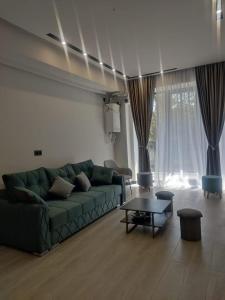 a living room with a green couch and a table at Spacious Apartment in Yerevan, CENTRE in Yerevan