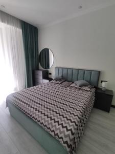 1 dormitorio con 1 cama grande y espejo en Spacious Apartment in Yerevan, CENTRE en Ereván