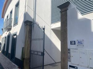 um edifício branco com um portão numa rua em Cube30 em Águeda