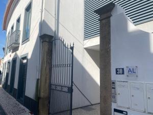 a white building with a gate on a street at Cube30 Águeda - Alojamento Local 1 in Águeda