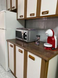 a kitchen counter with a microwave and a refrigerator at Cabrales236 Casa con jardín en Carreña de Cabrales in Carreña de Cabrales 