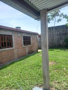 a brick house with a pillar in the yard at Flia Perez Derrache in Ituzaingó