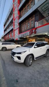 une voiture blanche garée devant un hôtel dans l'établissement Baltistan Continental, à Skardu